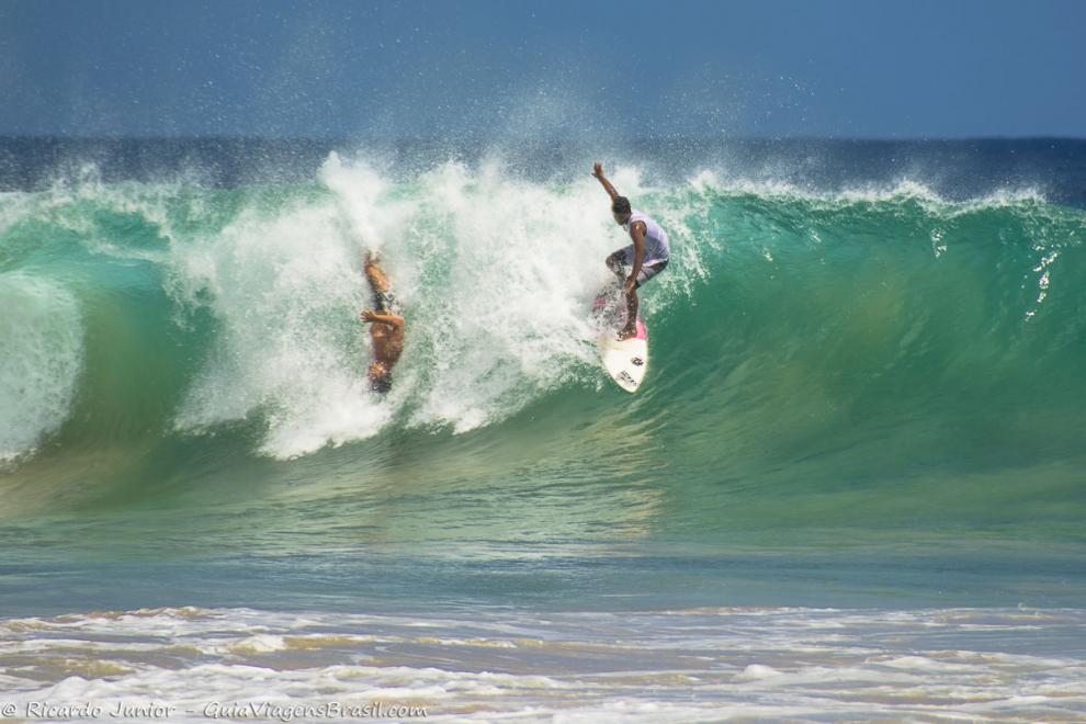 Imagem de dois surfistas nas águas faulosa de Noronha.